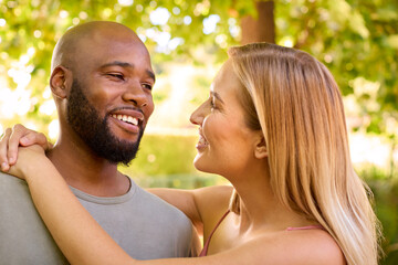 Fototapeta premium Portrait Of Loving Multi-Racial Couple Standing Outdoors In Garden Park Or Countryside