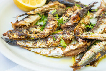Plateful of Grilled Sardines Served with a Slice of Lemon in a Restaurant in Greece