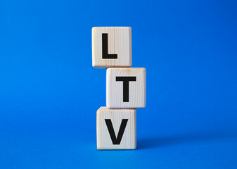 LTV - Life Time Value symbol. Concept word LTV on wooden cubes. Beautiful blue background. Business and LTV concept. Copy space.