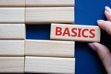 Basics symbol. Concept word Basics on wooden blocks. Businessman hand. Beautiful deep blue background. Business and Basics concept. Copy space.