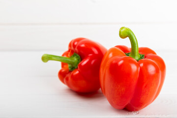 Fresh colorful red bell pepper on white textured wooden background. Bell pepper. Vegetables. Vegan food. Healthy foods. Place for text. Place to copy. Diet concept.