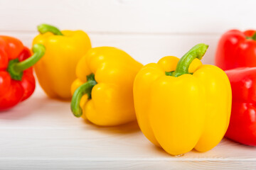 Fresh colorful red and yellow bell peppers on a white wooden background. Bell pepper. Vegetables. Vegan food. Healthy foods. Place for text. Place to copy. Diet concept.