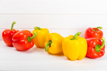 Fresh colorful red and yellow bell peppers on a white wooden background. Bell pepper. Vegetables. Vegan food. Healthy foods. Place for text. Place to copy. Diet concept.
