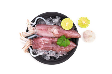 Fresh raw octopus, and seafood on black plate with ice. Lemon slice. Top view. It is isolated on...