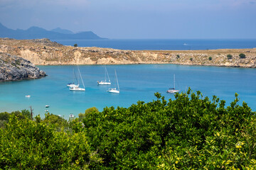 Fototapeta na wymiar High View of the Mediterranean Sea in Lindos Rhodes Dotted With Sailboats