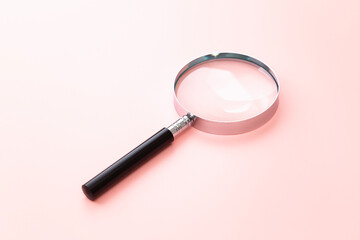 ピンク背景の虫めがね