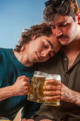 Couple of men toasting draft beer against the sunset.