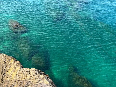 Aerial view sea water turquoise blue and rocky coast. 
