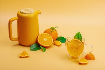 Orange tea in ceramic tea pot with ripe fruits. Refreshment seasonal drink, conceptual background