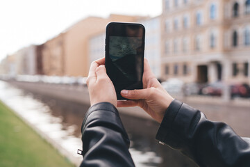 Crop person taking photo on smartphone