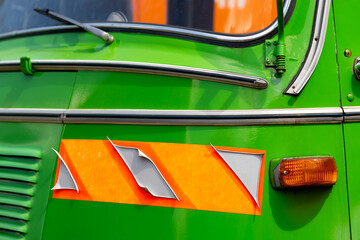 Blinker or indicator on the front of a historic oldtimer truck in bright sunlight. Green livery...