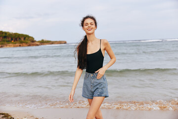 Fototapeta na wymiar woman sunset lifestyle summer smile ocean beach sand sea jean vacation
