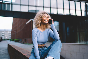 Fototapeta premium Positive black female having phone call on city street