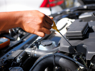 Fototapeta na wymiar car mechanic checking car engine oil level and car engine oil quality