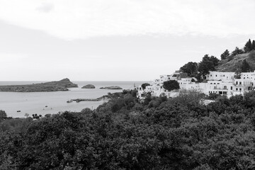 Black and white view of the Lindos Town, white house buildings along the St. Paul's bay coast