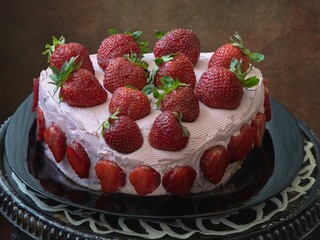 Homemade strawberry cake closeup on a round table