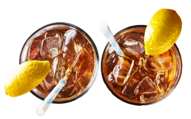 iced sweet tea with ice and paper straw with lemon wedge garnish on transparent background shot from overhead view 