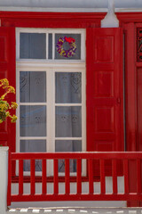 Old, red, wooden door of a white traditional house in Cyclades, Greece.