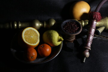 bowl of tobacco for hookah. smoking shisha. berries and fruits on a black background