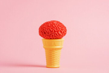 Ice cream in shape of human brain on waffle cone, pink background.  Creative funny postcard idea.