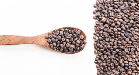 Obraz premium Coffee beans in a spoon isolated on white background