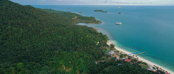 Panoramic aerial drone view of tropical island scenery with lush green forest trees at Tinggi Island or Pulau Tinggi in Mersing, Johor, Malaysia