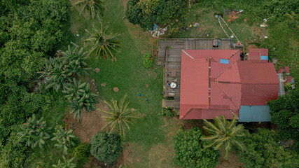 Aerial drone view of lush green island scenery with a single house at Tinggi Island or Pulau Tinggi in Mersing, Johor, Malaysia