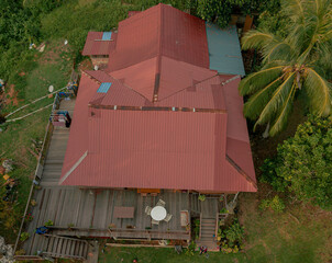 Aerial drone view of lush green island scenery with a single house at Tinggi Island or Pulau Tinggi in Mersing, Johor, Malaysia