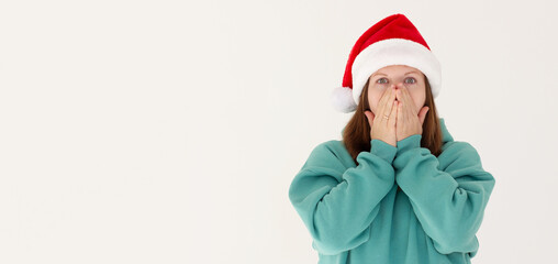 Surprised christmas pregnant girl wearing a santa hat isolated on white background