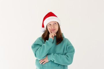 Photo of funny pretty pregnant lady celebrate winter holidays dreamy look empty space think family party hand on chin x-mas concept wear santa cap isolated white color background