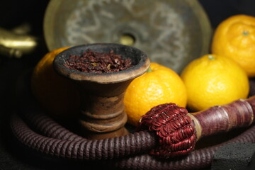 bowl with tobacco for hookah. shiisha smoking. berries and fruits on a black background.
