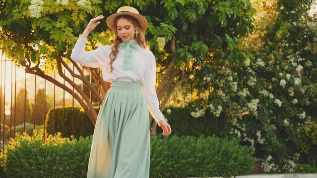 art portrait fashion model adult girl walks enjoy summer nature green trees white flowers garden park, straw hat red hair cute face. Young happy smiling vintage woman mint color retro style dress lady
