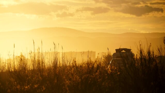 Coastal sunset landscape with caravan trailer wild camping on beach. Capi Corb, Mediterranean coast of Spain. Holidays, traveling with motorhome.