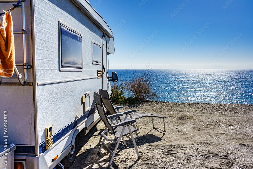 Poster rv camper camping on sea shore, spain.