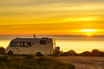 Caravan on sea at sunrise.