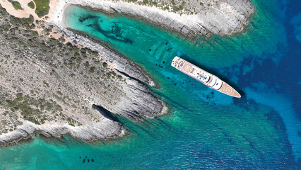 Aerial drone photo of beautiful turquoise beach and cave formations visited by yachts in Southern...