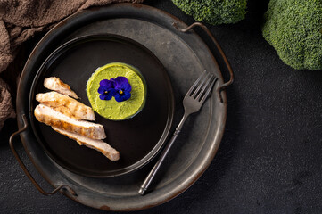 Broccoli puree with grilled chicken breast. Top view.