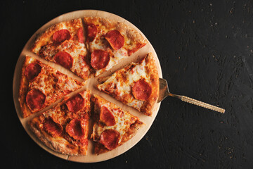 Pepperoni pizza with sausage dark background.