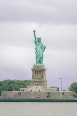 Fototapeta premium The Statue of Liberty on a Partly Sunny Day at Sunrise