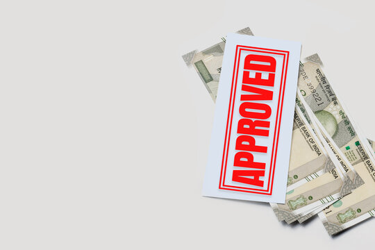 Bank loan approval concept: Indian currency and red stamp on white background with copy space.