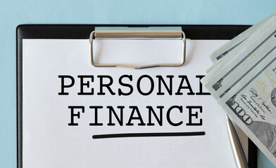 PERSONAL FINANCE text on a notebook with clipboard and calculator on a chart background