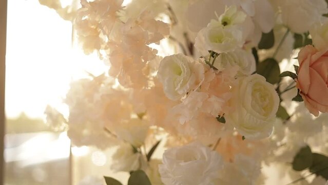 Close up of luxury floral arrangement of pastel colors, pink and white roses flowers. Part of festive decor, arch on wedding ceremony indoors, reception, dinner at the restaurant. Slow motion