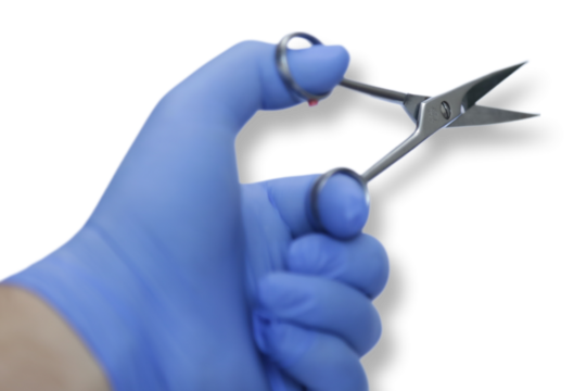 Tesoura de inox na mão de uma pessoa com luva azul.
