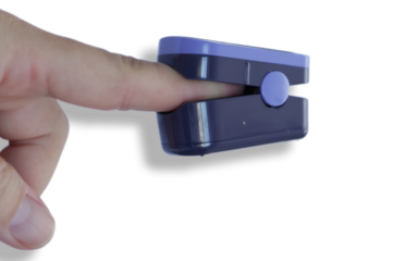 Oximetro no dedo de uma pessoa com fundo de cores.