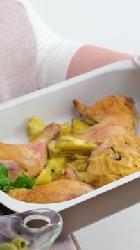 close-up of beige baking sheet on white background chicken ham baked apple potato baked salad woman with large breasts holds and turns baking 
