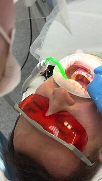 brushing teeth remove tartar and plaque Dental care and hygiene, adult caucasian dentist at work preparing teeth for implant Patient gum is bleeding because of dentist's intervention