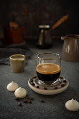 Iced coffee with milk, biscotti and merengue on dark background 