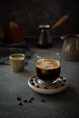 Iced coffee with milk, biscotti and merengue on dark background 