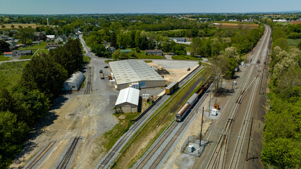 An Aerial View of a Steam Locomotive Moving Freight Cars Around in a Freight Yard to Organize a Freight Train on a Sunny Day
