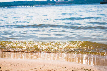 Sparkling silver waves in the sand. Summer beach background with a space for text.